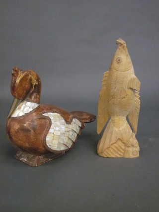 A carved wooden figure of a bird and do. fish