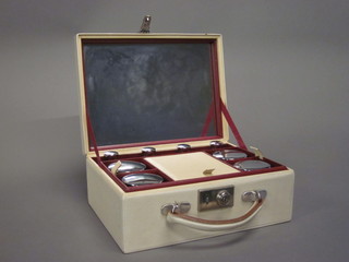 A lady's 1950's white leather vanity case with hinged lid, fitted 8 glass bottles with chrome tops