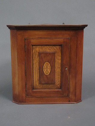 A 19th Century oak and mahogany hanging corner cabinet with  moulded cornice, enclosed by panelled doors 19"