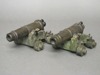A pair of bronze model cannons with 9" barrels raised on  wooden trunion  ILLUSTRATED