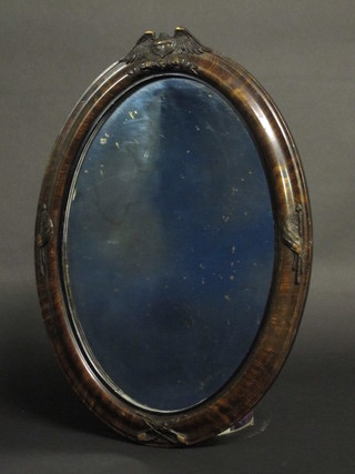 An American oval plate wall mirror contained in a carved wood  frame surmounted by a crest, marked USA with with crossed  muskets 24"