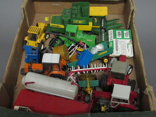 A shallow box containing a collection of Britains farm  machinery models etc