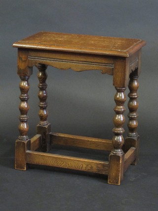A rectangular honey oak joyned stool, raised on bobbin turned  supports 17"