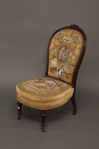 A carved rosewood show frame nursing chair the seat and back upholstered in Berlin woolwork, raised on turned and fluted  supports