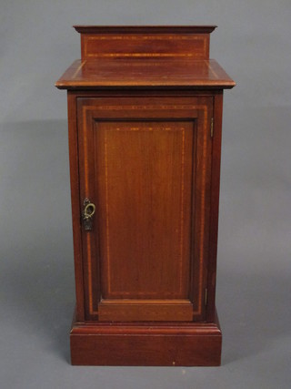 An Edwardian inlaid mahogany bedside cabinet enclosed by a  panelled door, raised on platform base 16"