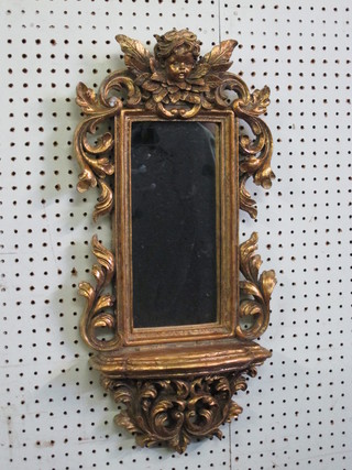 A plate wall mirror contained in a gold frame decorated a cherub and with shelf 24"