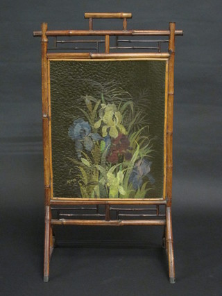A bamboo framed firescreen with central glass panel