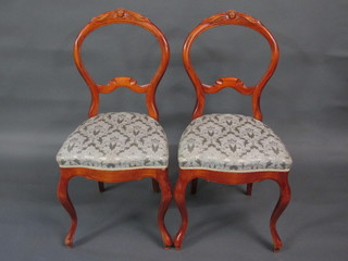 A pair of Victorian style bleached mahogany balloon back dining chairs with shaped mid rails and upholstered seats, raised on  cabriole supports