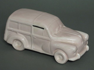 A pink glazed pottery money box in the form of a Morris Minor traveller, 9"