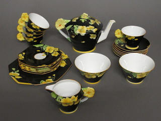 A 22 piece Paragon Iceland Art Deco Poppy pattern tea service comprising teapot, lozenge shaped plate 10", 6 square tea plates  6", 2 sugar bowls - 1 cracked, milk jug, 5 cups - 3 cracked, 6  saucers, some contact marks