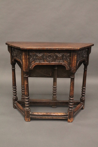A 1930's carved oak Credence table fitted a drawer and raised on turned and block supports 36"