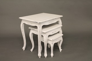 A nest of 3 white painted interfitting coffee tables, raised on cabriole supports 24"