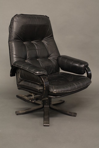 An Eames style ebonised revolving chair upholstered in black leather