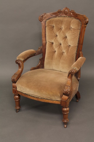 A Victorian carved walnut show frame open arm chair  upholstered in brown material, raised on turned supports