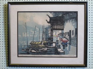 An Oriental limited edition coloured print "Figures by a River with Boats" 12" x 17" indistinctly signed to the margin