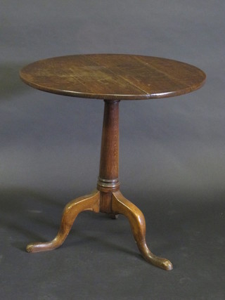 An 18th/19th Century circular oak tea table, raised on a gun  barrel column with tripod base, 27"