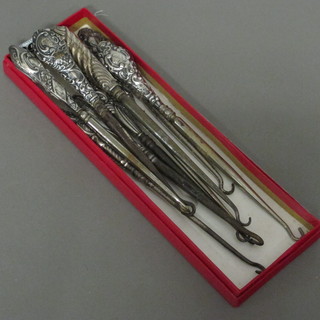 9 various silver handled button hooks