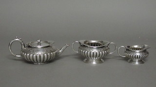A 3 piece Britannia metal tea service of melon form and demi-reeded decoration, comprising teapot with hinged lid - f,  twin handled sugar bowl and milk jug