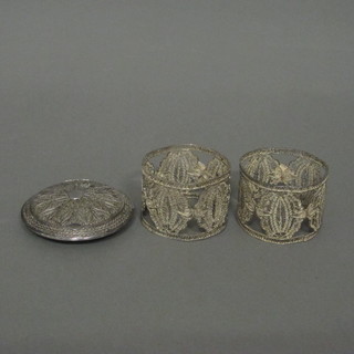 A silver filigree compact and a pair of pierced filigree napkin rings