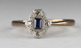 A gold dress ring set a blue stone supported by diamonds