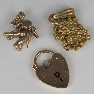 A gold padlock clasp, a gold nugget charm and a gold pendant in  the form of an elephant