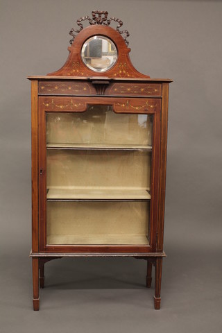 An Edwardian mahogany Adam style display cabinet, the raised back fitted a circular bevelled plate mirror, the interior fitted  shelves enclosed by glazed panelled doors, painted swags  throughout, raised on square tapering supports 27"   ILLUSTRATED