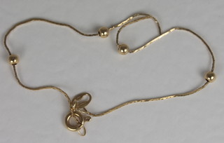A gold bracelet interspaced with spheres