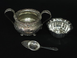 A Victorian style silver plated twin handled sugar bowl, a silver plated dish and a silver plated tea strainer