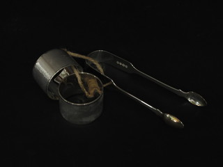 A pair of William IV silver fiddle patterned sugar tongs, London 1836 and a pair of silver napkin rings with engine turned  decoration Birmingham 1932, 4 1/2 ozs