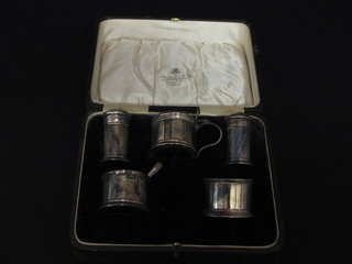 A silver 5 piece condiment set comprising pair of salts, pair of pepper pots, mustard pot, blue glass liner missing from salt,  Birmingham 1928, cased