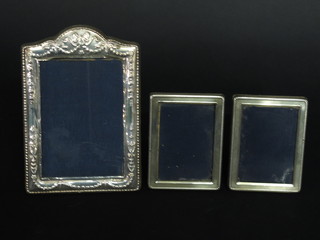 An easel photograph frame with embossed decoration and a pair of small silver easel photograph frames 4" x 3"