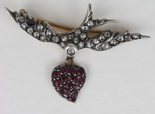 A gold brooch in the form of a dove bearing a heart set rubies  and diamonds,
