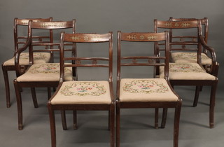 A set of 6 Regency style mahogany bar back dining chairs with  inlaid brass decoration and upholstered drop in seats, raised on  sabre supports