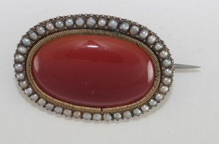 A Victorian gilt metal oval brooch set polished hardstone  surrounded by demi-pearls