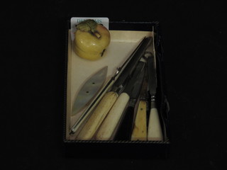 A carved ivory tape measure holder in the form of an apple and various manicure implements