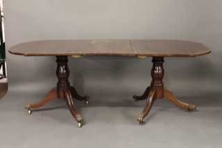 A Georgian style mahogany D end extending dining table with 2 extra leaves, raised on pillar and tripod supports