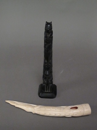 A carved section of ivory in the form of a crocodile 12" together with a resin totem pole 12"