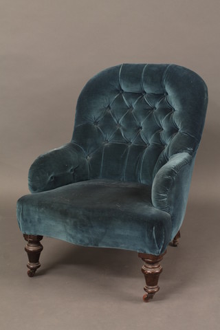 A Victorian mahogany framed tub back chair upholstered in blue buttoned material, raised on turned supports