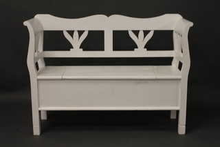 A white painted pine settle with pierced back and hinged seat 49"