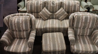 A 4 piece suite comprising pair of winged armchairs, a 3 seat  settee and matching footstool upholstered in green and white  striped material