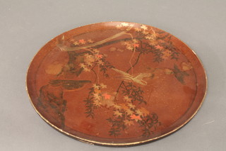 An Oriental circular red lacquered tray decorated birds amidst  branches 17"