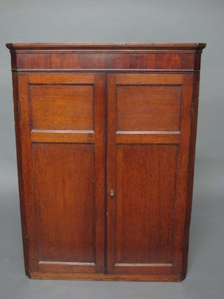 A Georgian oak and mahogany corner cabinet with moulded  cornice, fitted shelves enclosed by astragal doors 30"