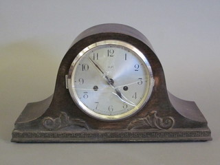 A 1930's striking mantel clock with silvered dial and Arabic  numerals contained in an oak Admiral's hat shaped case