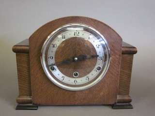 A 1930's chiming mantel clock with silvered chapter ring and  Arabic numerals by Anvil, contained in an oak arch shaped case