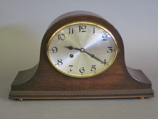 A 1930's 8 day mantel clock with silvered dial and Arabic  numerals contained in an oak Admiral's hat shaped case