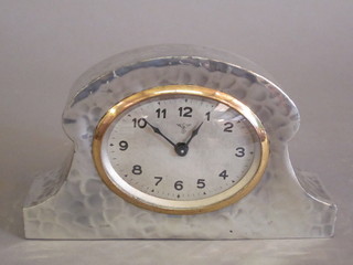 An Art Deco bedroom timepiece with silvered dial and Arabic numerals, the dial marked FMS contained in a planished pewter  arched case marked Castle Pewter, 6"