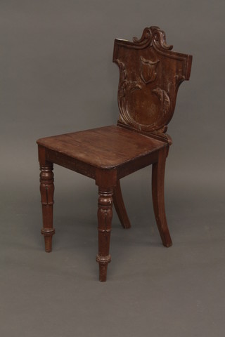 A Victorian mahogany hall chair with shield shaped back and  solid seat, raised on turned supports