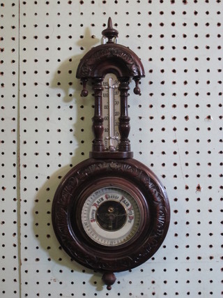 An aneroid barometer and thermometer with enamelled dial contained in a carved walnut case