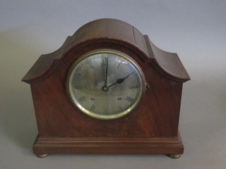An Edwardian striking mantel clock with silvered dial and  Roman numerals contained in a mahogany arch shaped case