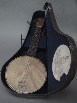 A 4 stringed banjo by John Grey & Sons, complete with case